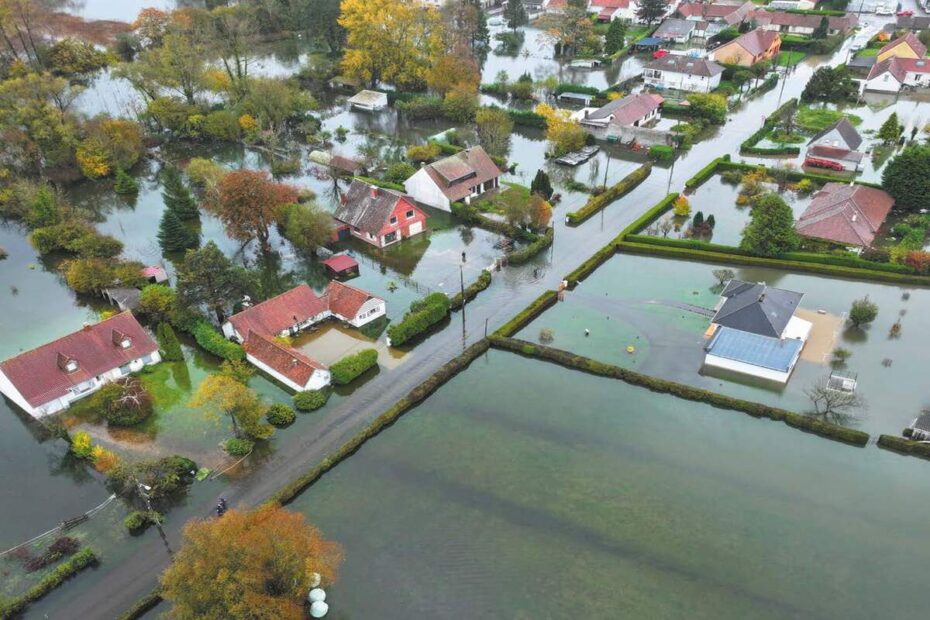 Paysage rural avec rivière en crue et zones partiellement submergées