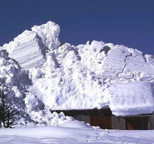 Accumulation massive de neige sur une toiture après une avalanche coulante