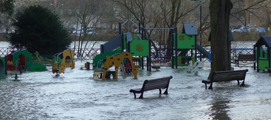 Photographie d’une aire de jeux inondée avec des structures pour enfants et des bancs partiellement submergés, illustrant les effets d’une crue en Bourgogne-Franche-Comté.