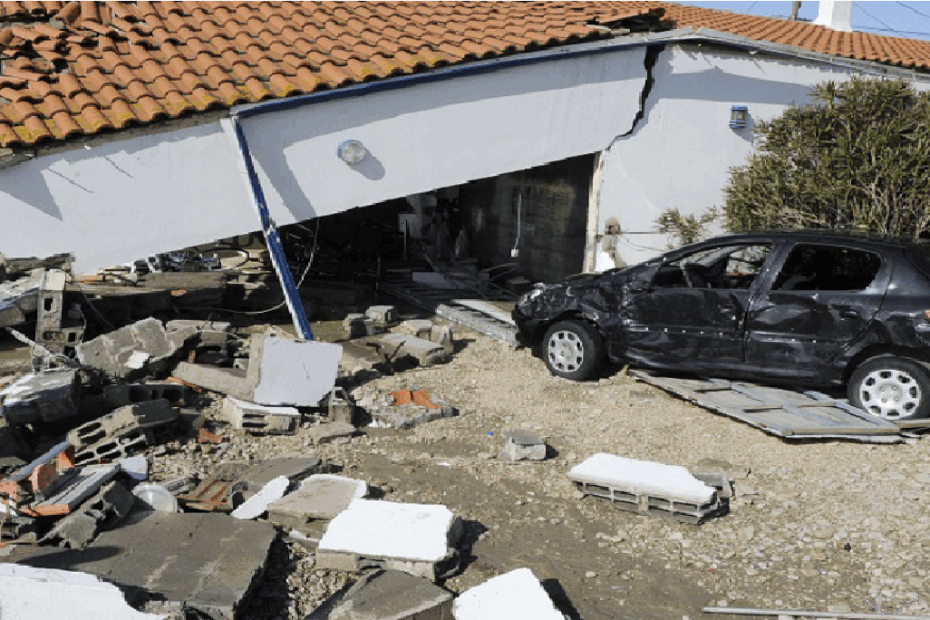 Maison effondrée et voiture endommagée après une catastrophe naturelle.